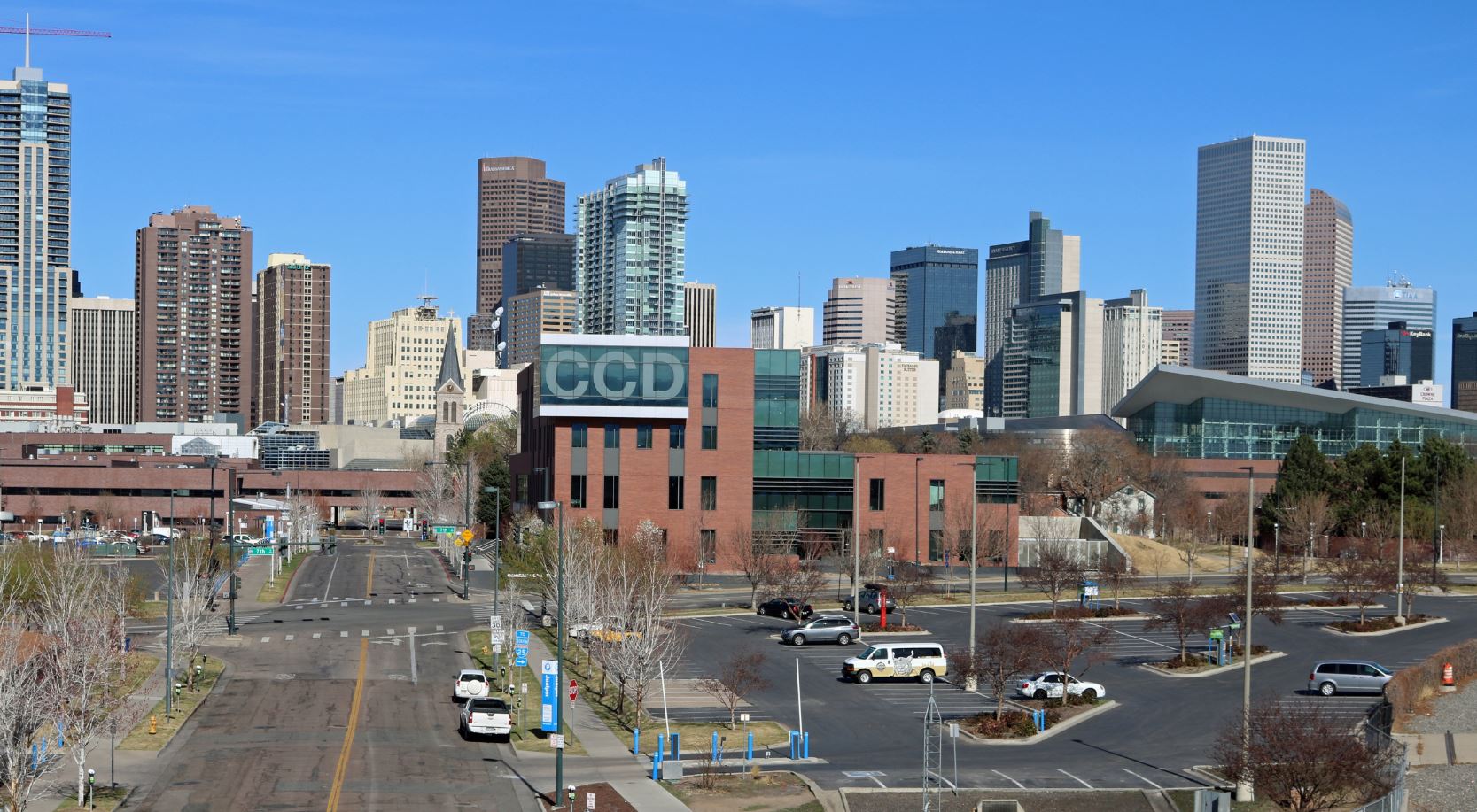 An image of the downtown Denver skyline, shot from the vantage showing buildings and streets and high-rise buildings.