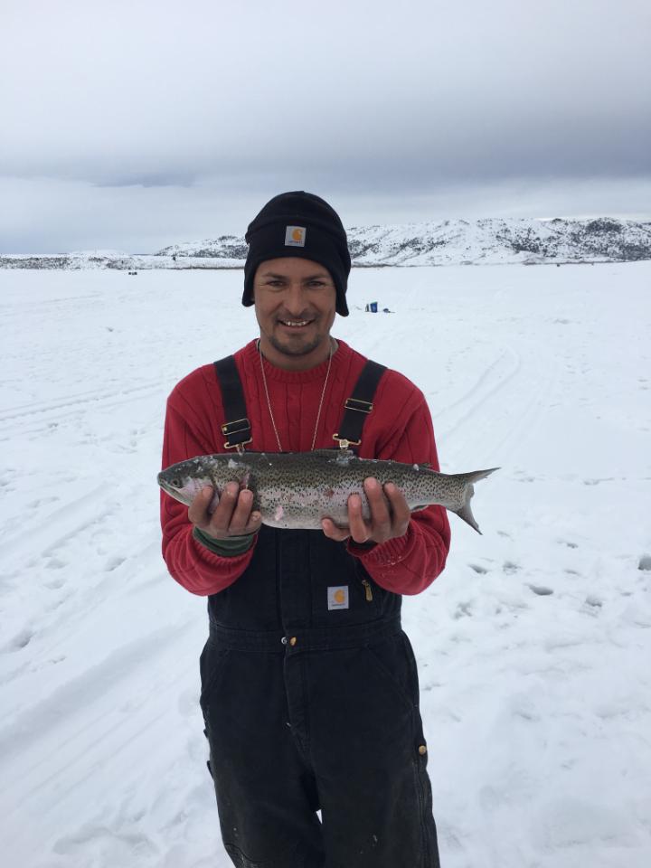 A lucky fisherman pulls in a beautiful rainbow trout during the Williams Fork Ice Fishing Tournament.