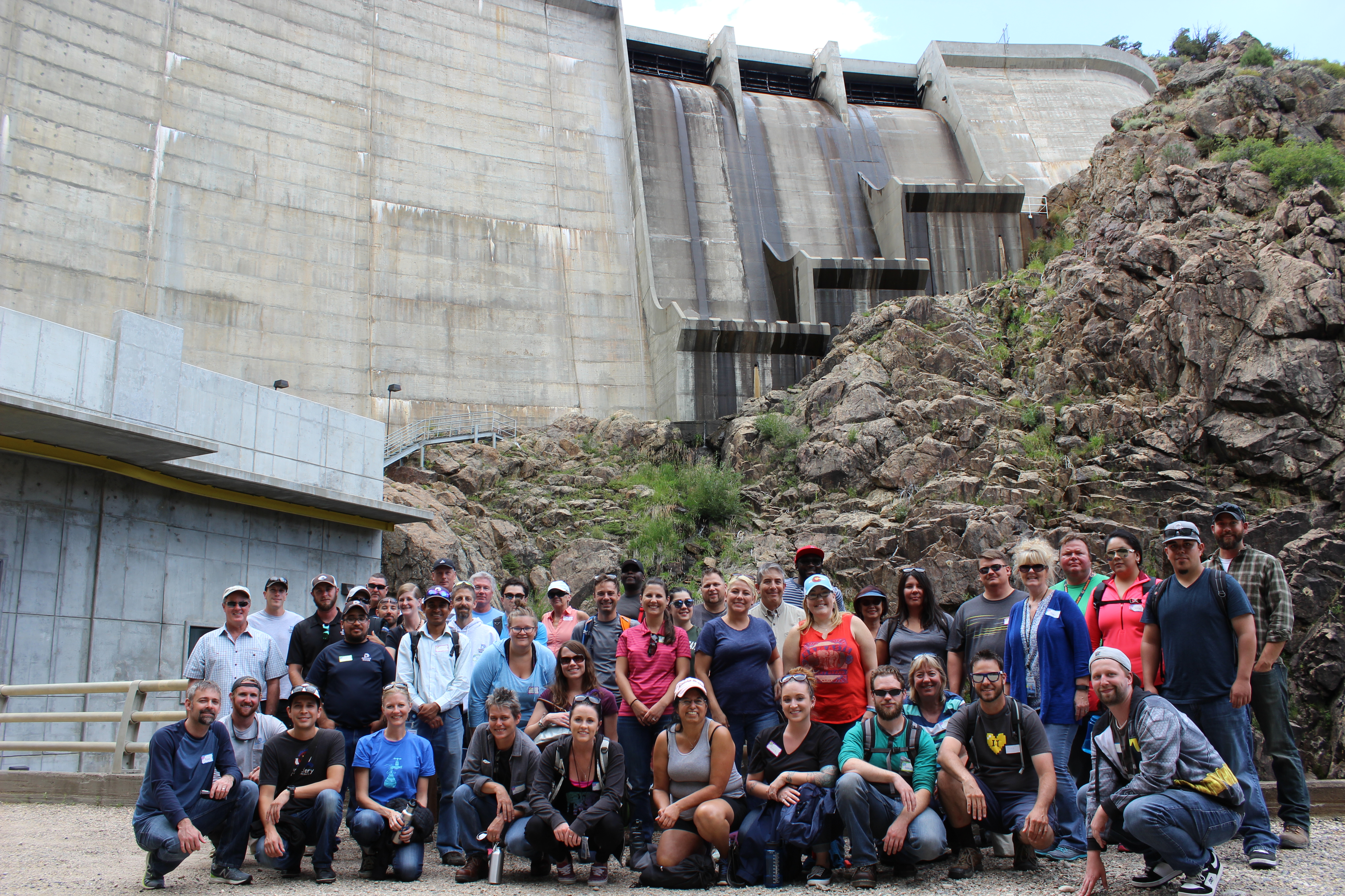Employees gather in front of the Williams Fork dam after touring the hydroelectric plant.