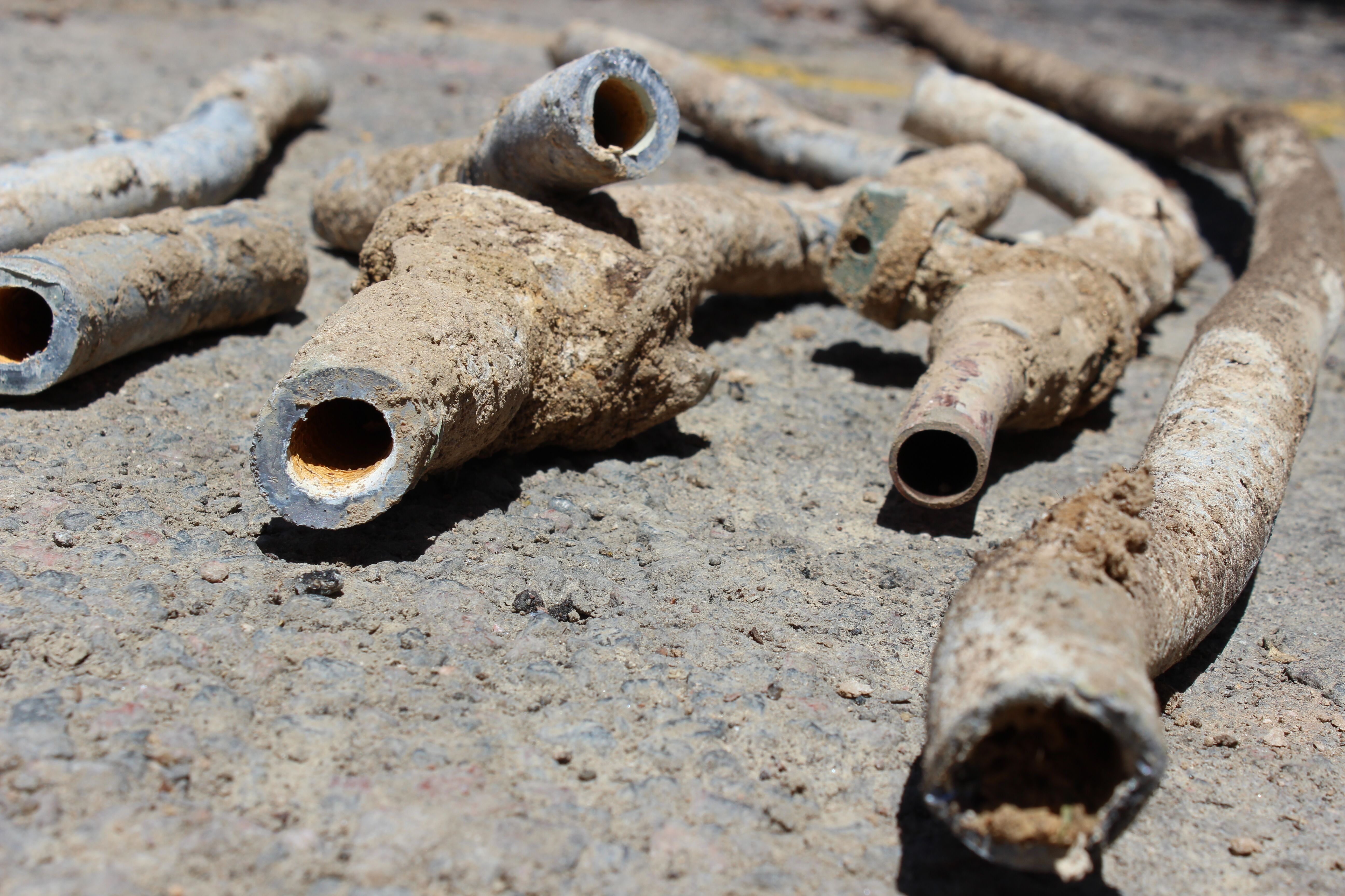 Pieces of old water pipe lay in the street.