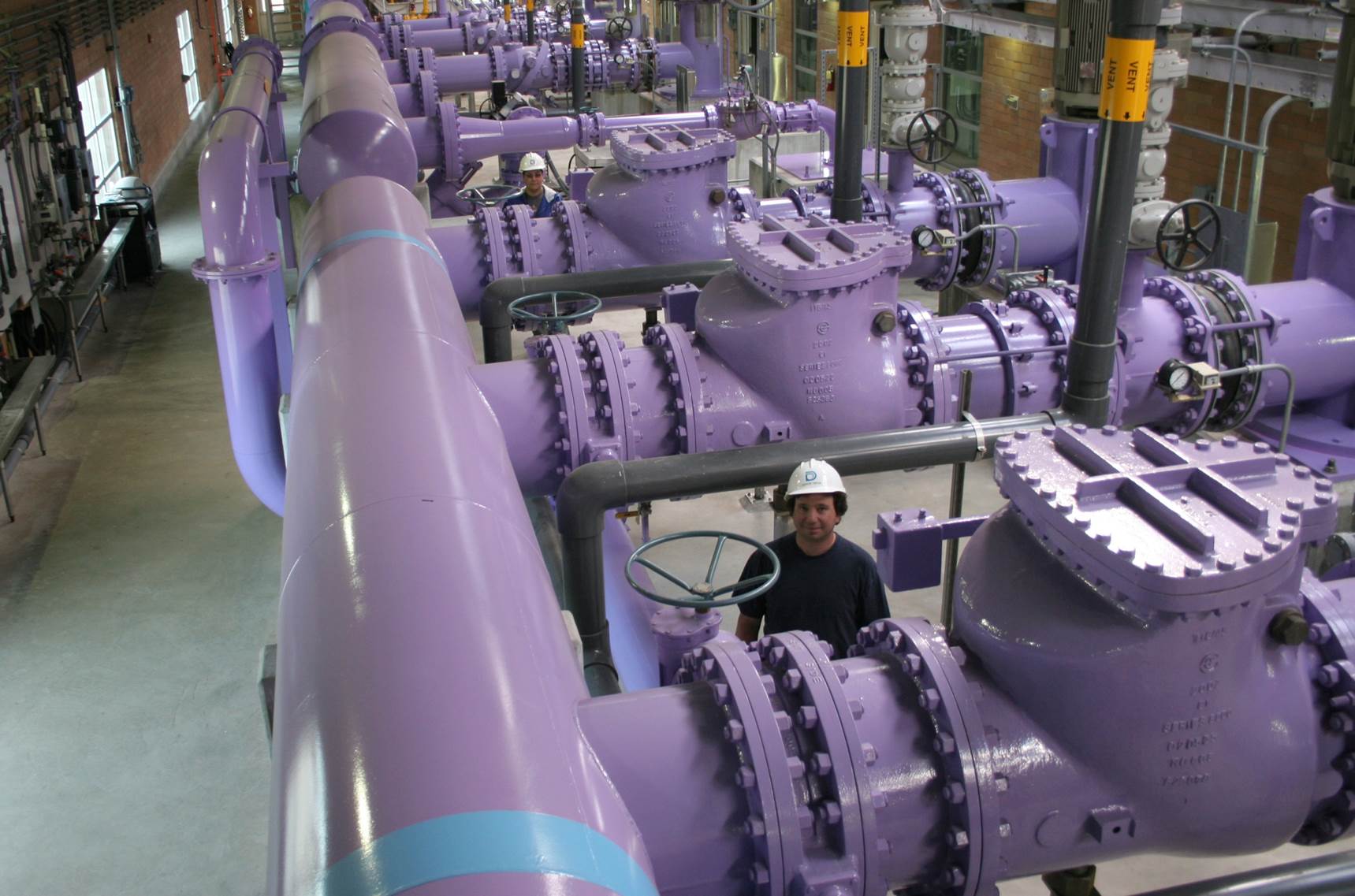 Construction crews install a 20-foot section of purple pipe in Denver's Stapleton neighborhood.