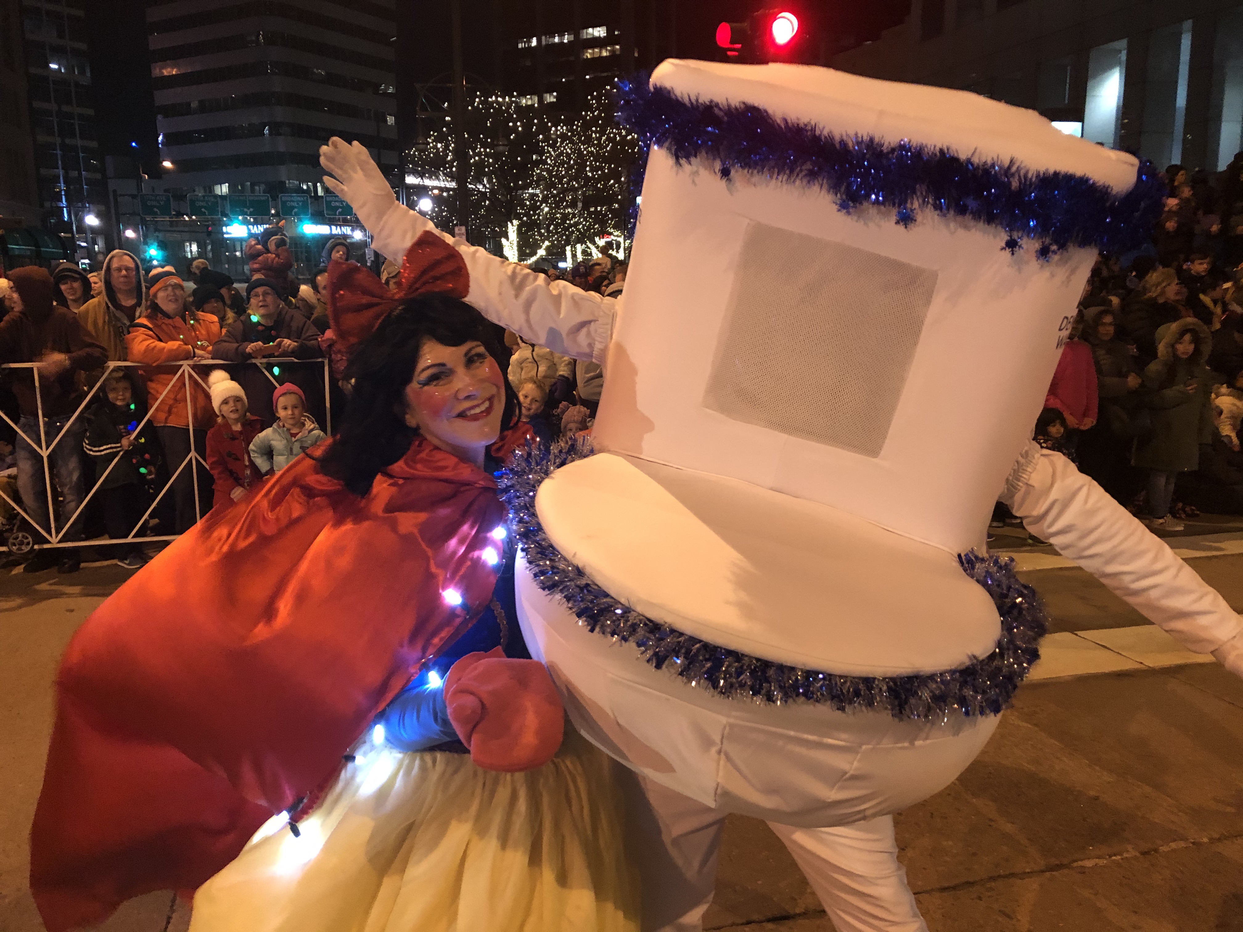A man in a toilet costume stands next to a smiling woman in a Snow White costume.