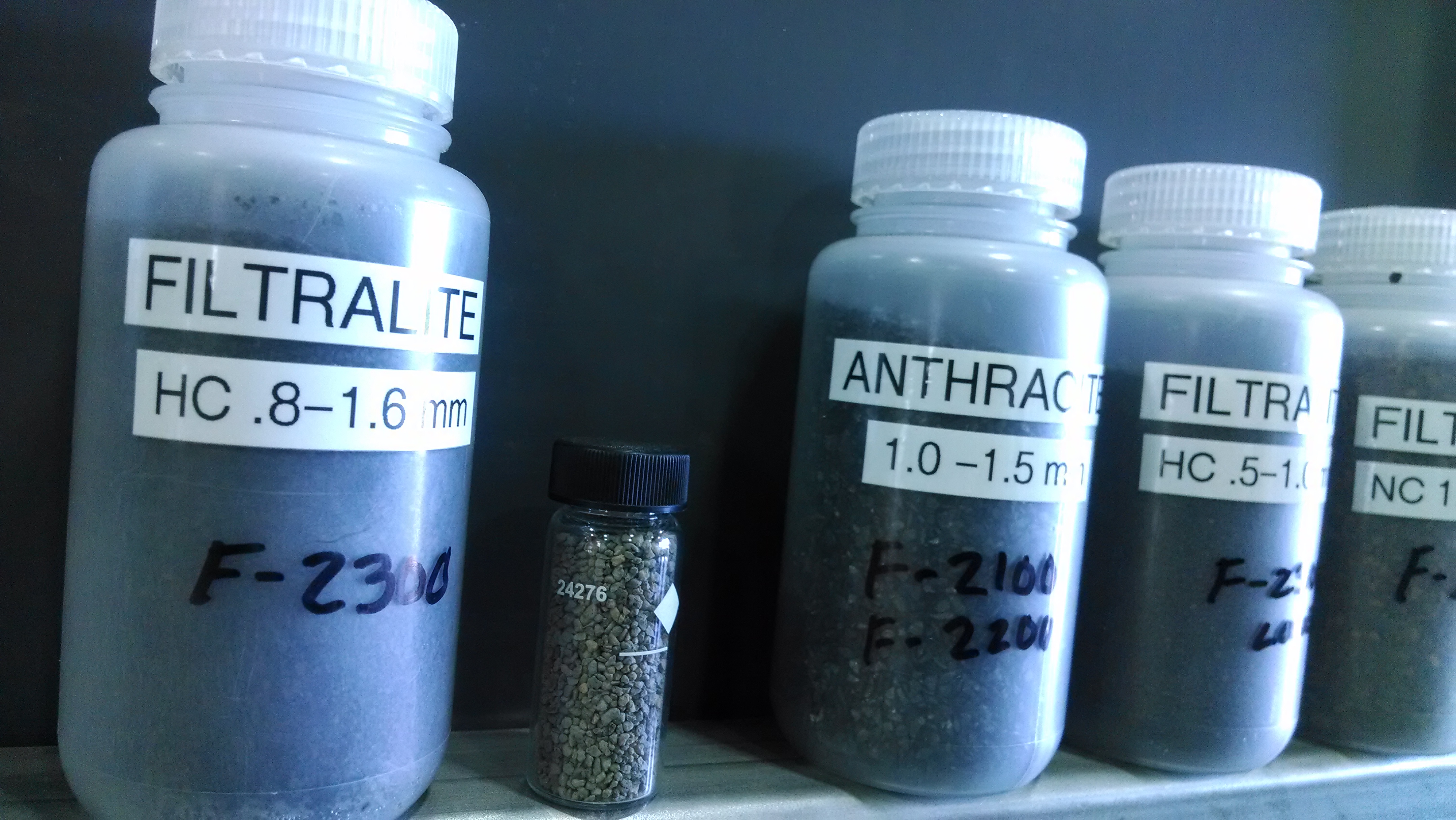 Plastic and glass vials marked with the names of the filter material and the sizes, which are about 1 milimeter.